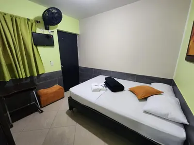 a bedroom with a bed with a bag on it at Hotel Laureles Home in Medellín