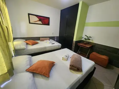 a room with two beds in a room at Hotel Laureles Home in Medellín