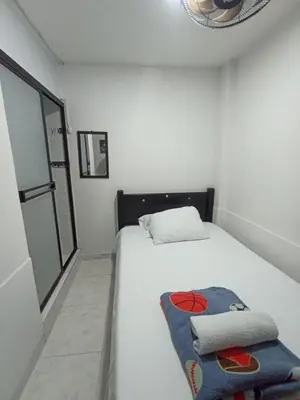 a small bedroom with a white bed and a window at Hotel San Vicente in Medellín