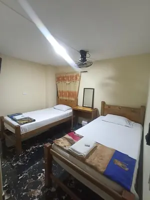 a room with two beds and a light on the ceiling at Hotel San Vicente in Medellín