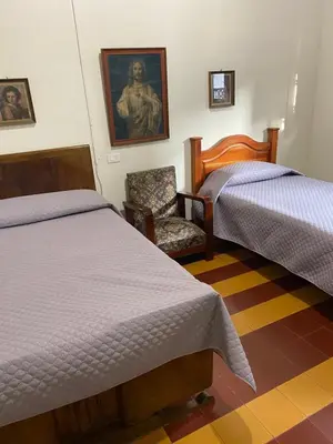 a hotel room with two beds and a chair at Vivienda Turística - Casa de Carola in Jardin