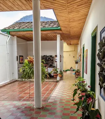 an indoor patio with a wooden ceiling and a table at Vivienda Turística - Casa de Carola in Jardin