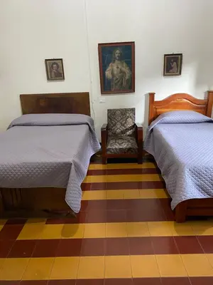 a room with two beds and a chair in it at Vivienda Turística - Casa de Carola in Jardin