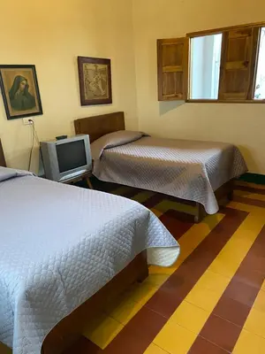 a hotel room with two beds and a tv at Vivienda Turística - Casa de Carola in Jardin