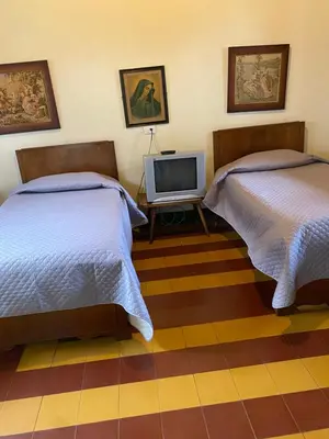 a bedroom with two beds and a tv on a tiled floor at Vivienda Turística - Casa de Carola in Jardin