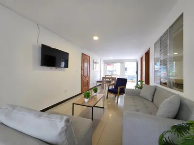 a living room with a couch and a tv on a wall at Casa amplia y cómoda cerca del Estadio y la 70 in Medellín