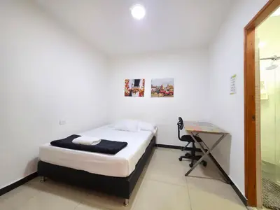 a small bedroom with a bed and a desk at Casa amplia y cómoda cerca del Estadio y la 70 in Medellín