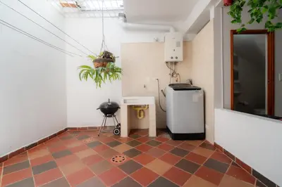 a room with a tiled floor with a small refrigerator at Casa amplia y cómoda cerca del Estadio y la 70 in Medellín