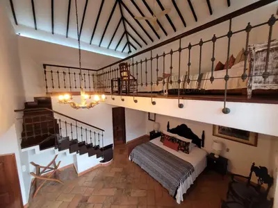 a bedroom with a bed in a room with stairs at Hotel Boutique Al Alma in Santa Fe de Antioquia