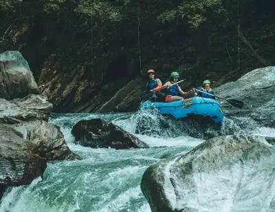 a group of people in a raft in a river at El Tigrillo Rio Claro by Los Colores Ecoparque in Doradal