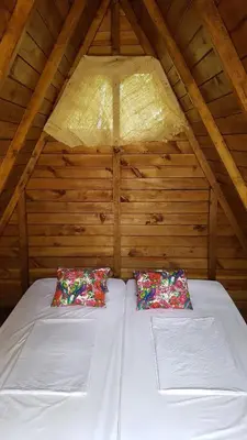 a bed in a attic with two pillows on it at El Tigrillo Rio Claro by Los Colores Ecoparque in Doradal