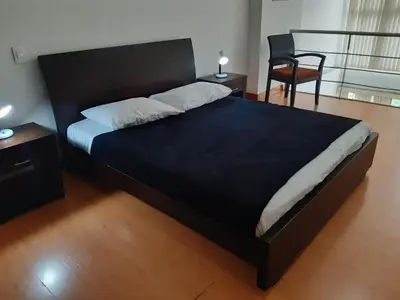 a bedroom with a large black bed with a chair at Rent Apartment Furnished an alcove in Medellín