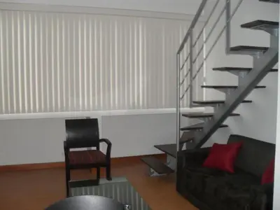 a living room with a spiral staircase and a chair at Rent Apartment Furnished an alcove in Medellín