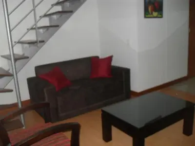 a living room with a black couch with two red pillows at Rent Apartment Furnished an alcove in Medellín