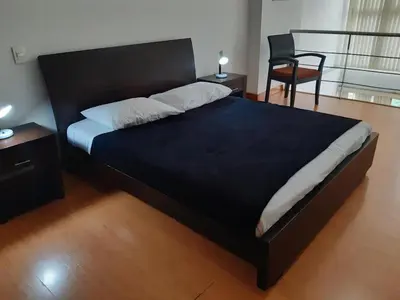 a bedroom with a large black bed and a chair at Rent Apartment Furnished an alcove in Medellín