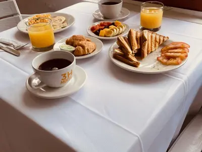 a table with plates of breakfast foods and a cup of coffee at Casa Hotel Solare de la 70 in Medellín