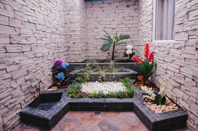 a garden with flowers and rocks in a brick wall at Casa Hotel Solare de la 70 in Medellín