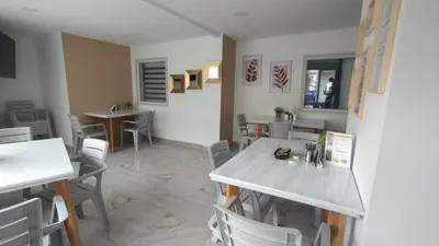 a dining room with chairs and a table and tables at Casa Hotel Solare de la 70 in Medellín