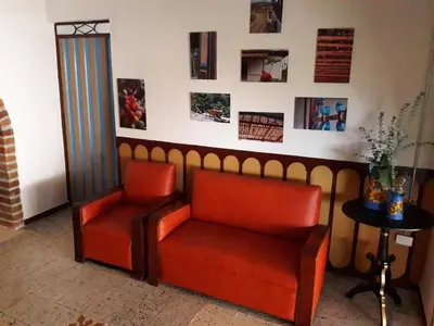 two chairs in a waiting room with pictures on the wall at Hacienda Cafetera La Gaviota in Chinchiná