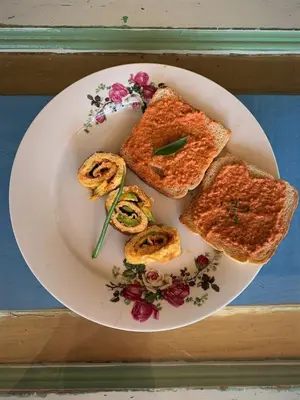 a white plate with toast and vegetables on it at Hacienda Cafetera La Gaviota in Chinchiná