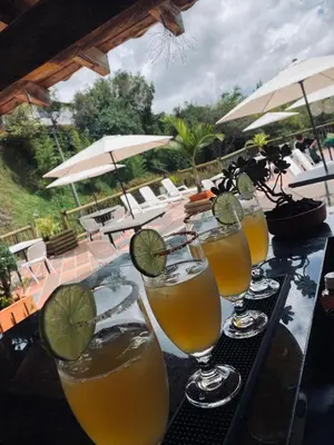 a row of glasses with a lime on a table at Hotel Estaciones in Guatapé