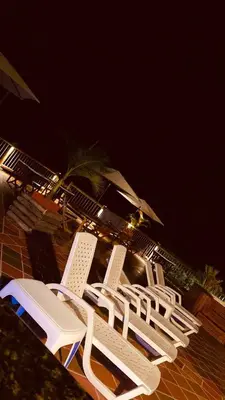 a group of lawn chairs sitting on a patio at night at Hotel Estaciones in Guatapé