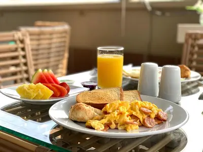 a table with plates of breakfast food and a glass of orange juice at Seven Inn Hotel in Medellín
