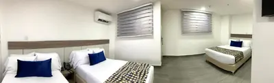 a hotel room with two beds with blue pillows at Seven Inn Hotel in Medellín