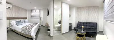 a bedroom with a bed and a chair and a bathroom at Seven Inn Hotel in Medellín