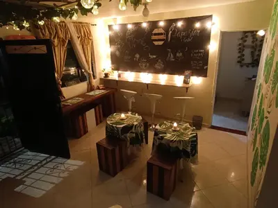 a restaurant with two tables and a black wall with lights at Pa Pasiar Hostal in Medellín