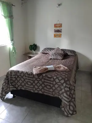 a bedroom with a bed with a blanket on it at Pa Pasiar Hostal in Medellín