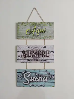 a group of wooden signs hanging on a wall at Pa Pasiar Hostal in Medellín