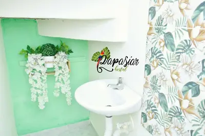 a bathroom with a sink and a toilet and flowers at Pa Pasiar Hostal in Medellín