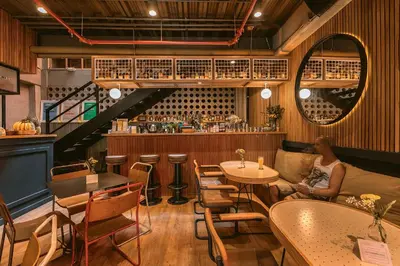 a woman sitting at a table in a restaurant at The Somos Beats Hotel & Rooftop in Medellín