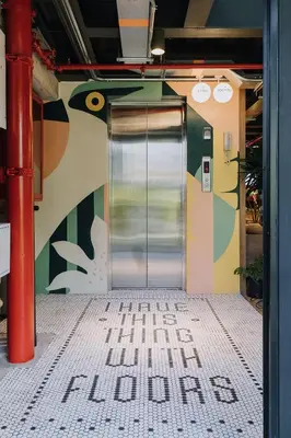 a metal door with a sign on the side of a building at The Somos Beats Hotel & Rooftop in Medellín