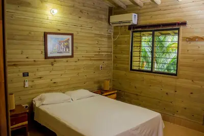a bedroom with a white bed and a window at Hostería Miraflores in Liborina