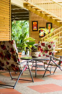 two chairs and a table in front of a house at Hostería Miraflores in Liborina