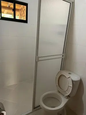 a bathroom with a toilet and a glass shower at Hostería Miraflores in Liborina
