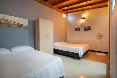 a bedroom with two beds and a fan at 5STARHOMES - Estilo y confort en Laureles in Medellín