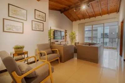 a living room with chairs and tables and a window at 5STARHOMES - Estilo y confort en Laureles in Medellín