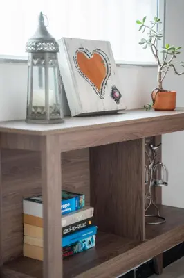 a table with a shelf with books and a lantern at 5STARHOMES - Estilo y confort en Laureles in Medellín