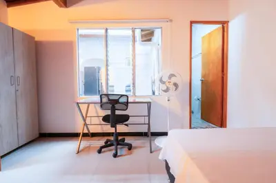 a bedroom with a desk and a bed and a window at 5STARHOMES - Estilo y confort en Laureles in Medellín