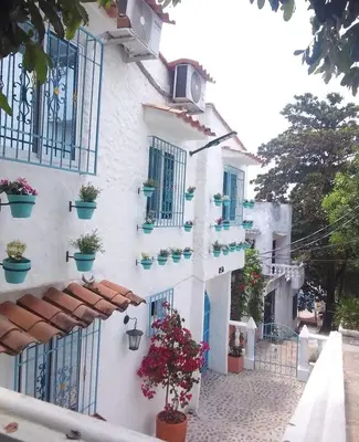a white building with potted plants on it at El santorini colombiano cabaña in Puerto Triunfo