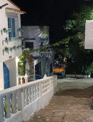 a house with a balcony at night at El santorini colombiano cabaña in Puerto Triunfo