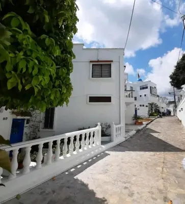 a white house with a white fence next to a street at El santorini colombiano cabaña in Puerto Triunfo
