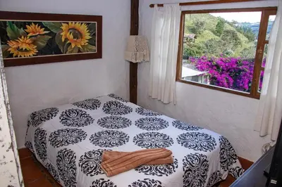 a bedroom with a bed and a window with a flower picture at Mini ISABELITA in El Retiro