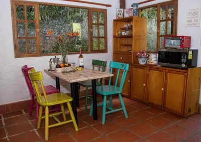 a kitchen with a table with colorful chairs at Mini ISABELITA in El Retiro