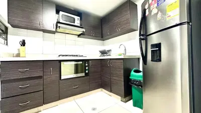 a kitchen with wooden cabinets and a stainless steel refrigerator at Apto Moderno en Laureles in Medellín