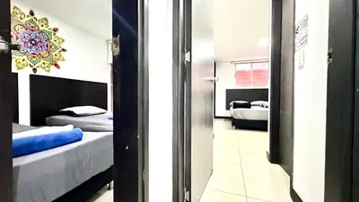 a room with two beds and a mirror at Apto Moderno en Laureles in Medellín