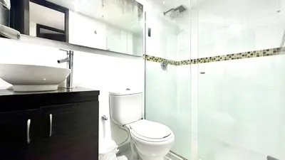 a bathroom with a toilet and a sink and a shower at Apto Moderno en Laureles in Medellín